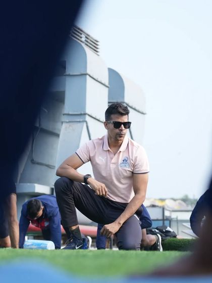 Crouched down, observing the players during a mobility drill. Attention to detail is everything.