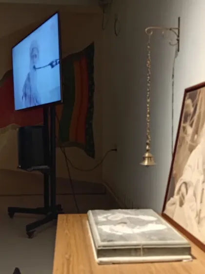 The setup for a Sadhguru Sanidhi Pooja, with his image, the Pada Yantra, and a screen for his live presence. Every element is arranged to enhance the feeling of his grace.
