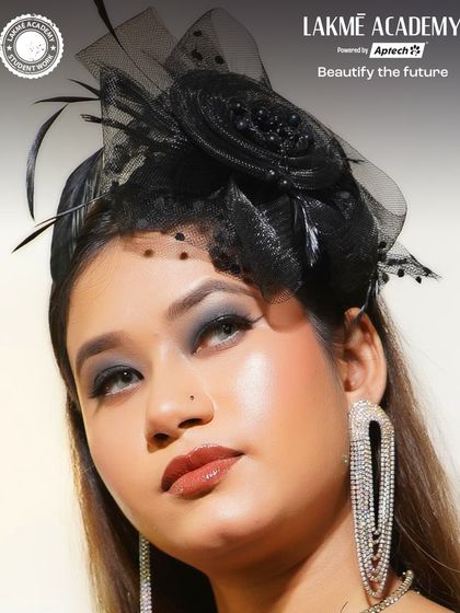 A showcase of student talent. This elegant look features a classic black fascinator, smoky eyes, and a glossy lip, demonstrating professional-level skill.