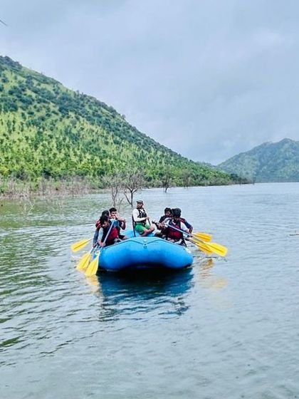 A rafting team paddles on the calm lake at Vani Vilas Sagar, a perfect spot for beginners to practice their strokes.