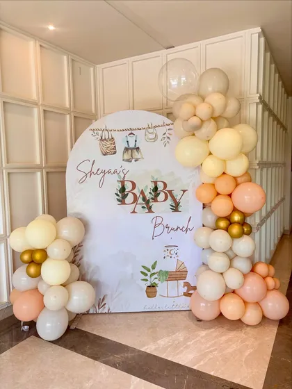 A closer look at the welcome sign and backdrop for Sheyaa's baby brunch. The custom-printed backdrop features charming illustrations that perfectly match the soft, neutral color scheme of the balloons.