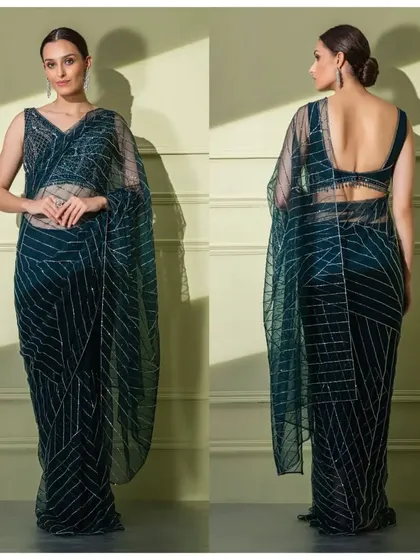 A full view of the teal geometric saree, showing the intricate line work and the modern, deep-V blouse design.