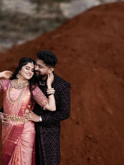 An intimate embrace against a backdrop of red earth. The contrast in colors makes this a visually striking and emotional portrait.