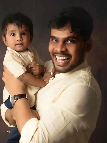 A father and son portrait radiating happiness. The dad's wide smile and the son's curious gaze make for a dynamic and heartwarming image.