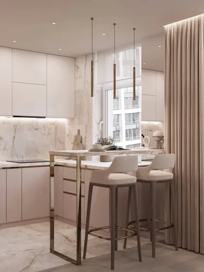 A minimalist kitchen with a breakfast bar. The soft pink cabinets and marble backsplash create a chic and contemporary look.