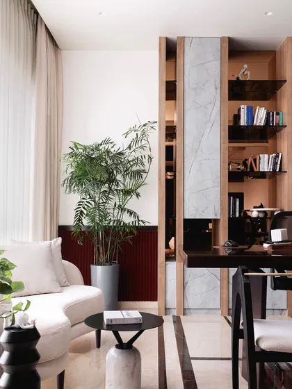 The home office includes a built-in bookshelf with marble accents, providing ample storage and a beautiful display area. The design seamlessly integrates work and living in a sophisticated way.