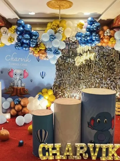 A cute elephant-themed first birthday with a blue and gold color scheme and a shimmer wall backdrop.