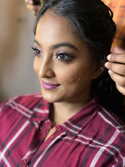 Another angle of Niveditha's reception look. The hairstyle and makeup work together to create a cohesive and stunning bridal look.