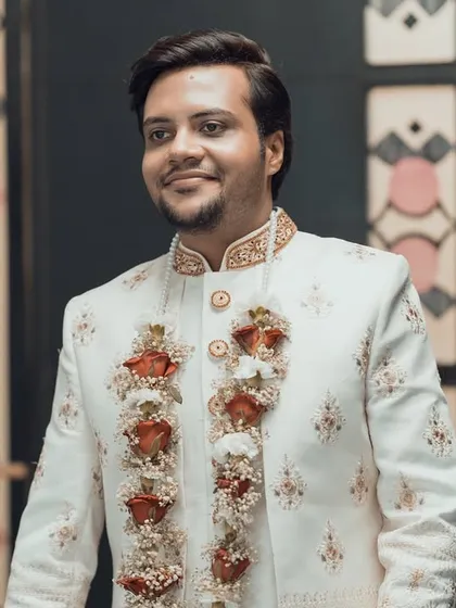 A handsome portrait of the groom in his elegant white sherwani, captured as he arrives for the ceremony.