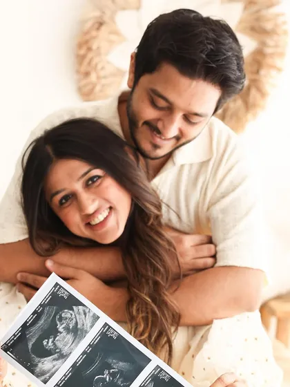 A joyful announcement. Her bright smile directed at the camera while he looks on lovingly makes this sonogram photo feel personal and celebratory.