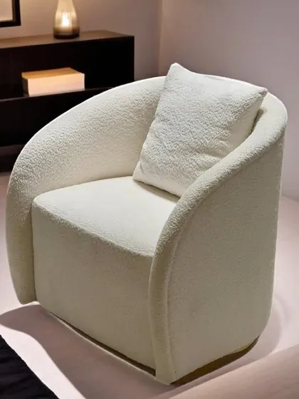 We designed this armchair as an exercise in sculptural comfort. Its curved form and plush bouclé upholstery create an inviting silhouette, offering a piece that is both a comfortable seat and a statement of minimalist luxury.