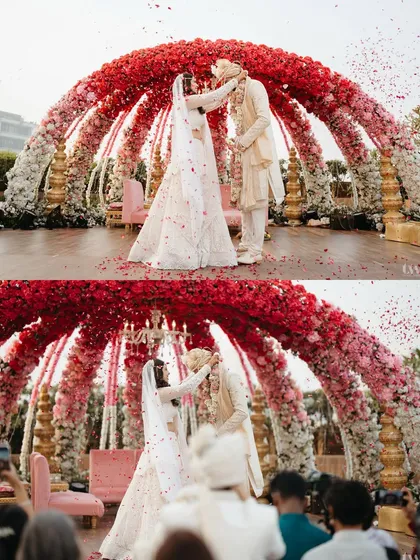 A two-part image showing the exchange of varmalas under a stunning red and pink floral arch. The shower of petals adds a touch of magic to the moment.