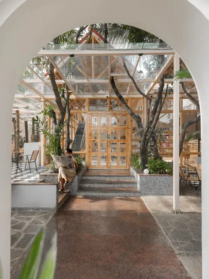 Another perspective of the entrance, highlighting the steps that lead up to the raised glass pavilion. The level change adds to the sense of journey and arrival.