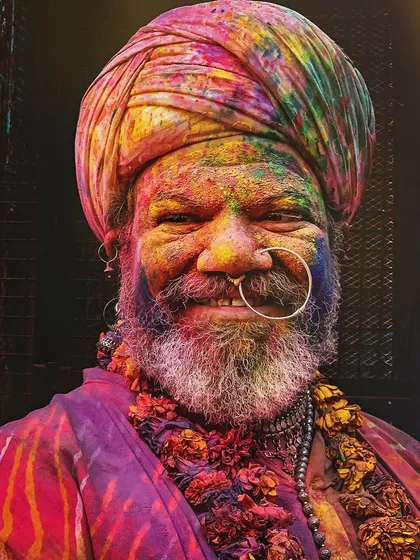 The vibrant energy of Holi in Vrindavan is pure joy. This candid street portrait captures the infectious happiness of a man immersed in the festival's colors, a moment where his spirit shines brightly and without reservation.