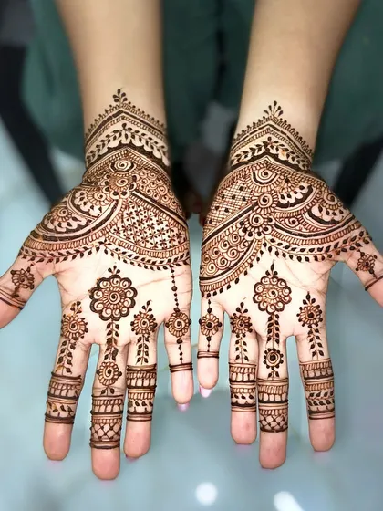 A delicate and spaced-out design on the back of the hands, featuring floral motifs connected by dotted lines for a minimalist feel.
