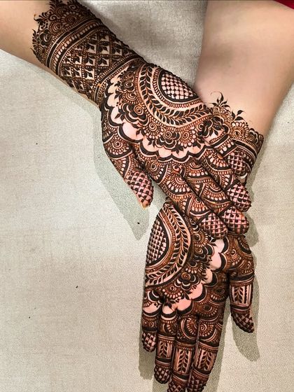 An elegant and intricate design featuring large paisley motifs on the palms, with detailed finger work and a beautiful cuff.