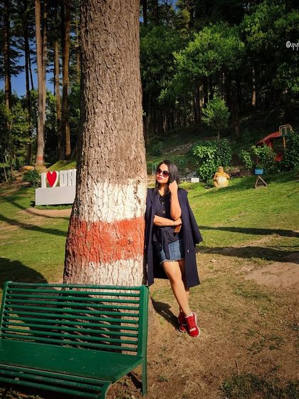 A casual and cool look for a day in the park, with a denim jacket, shorts, and bright red sneakers.