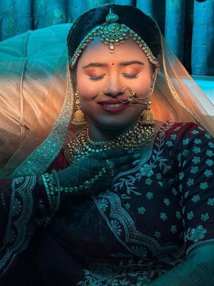 An artistic shot with blue lighting, creating a serene and dreamy mood. The bride's makeup looks ethereal and flawless.