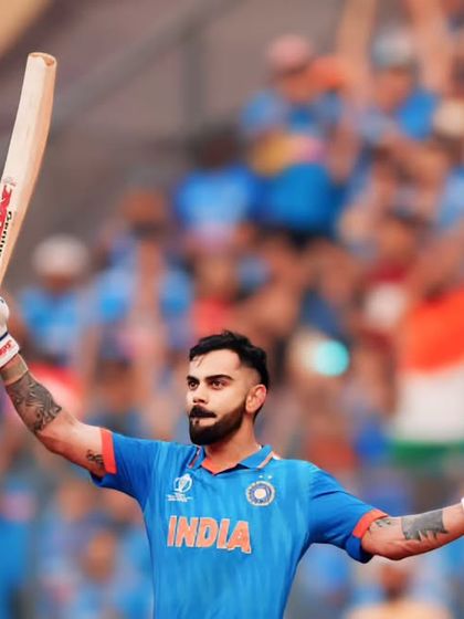 Arms outstretched in victory, Virat Kohli celebrates with the Indian flag in the crowd behind him. An iconic image of a national hero.