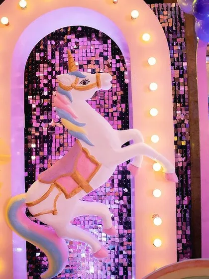 Another angle of the prancing unicorn prop, showing the sparkling sequin backdrop and the lit-up arch.