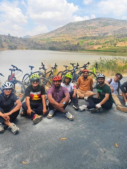 A happy group poses for a photo by the lake after a ride in the Nandi countryside. Community and fun are at the heart of everything we do.