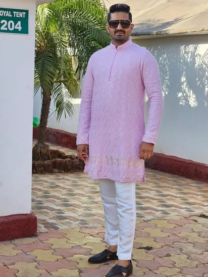 A happy client in a beautiful pink lucknowi-style kurta with intricate chikankari work. This is a classic and elegant choice for any celebration.