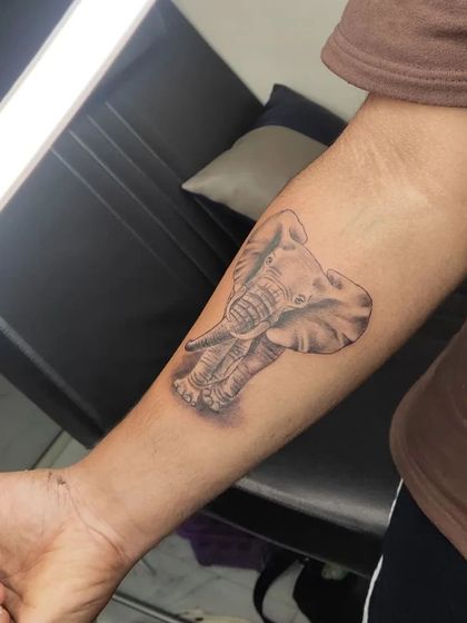 Another angle of the realistic elephant tattoo, showing how the piece wraps around the forearm.
