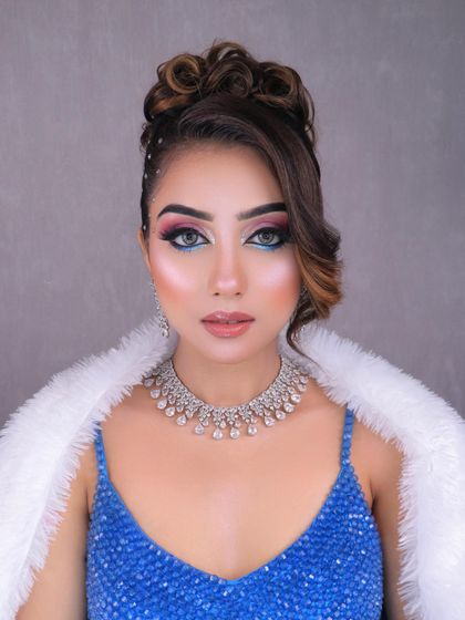 A stunning party look with a creative pink and blue eye, messy bun, and diamond jewelry. This shows the versatility of looks you can learn to create.
