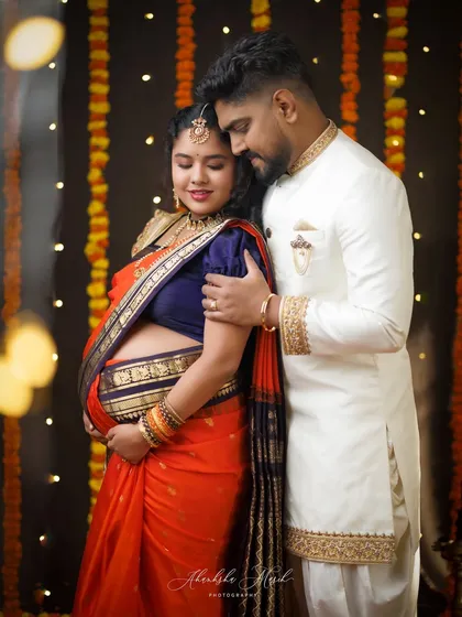 A beautiful family portrait with the couple in traditional attire, set against a backdrop of festive lights, creating a warm and celebratory feel.