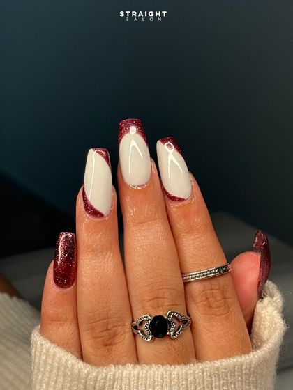 A close-up of the angled red glitter French tip. The contrast between the sparkling red and the crisp white is stunning.