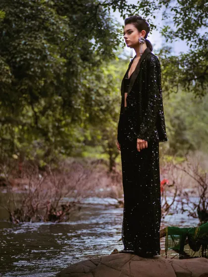 This wide shot from the Mind Magazine editorial places the high-fashion sequined outfit against a wild, natural backdrop, creating a stunning contrast between glamour and nature.