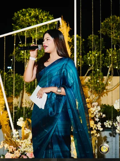 A solo shot from the same event, holding the mic and addressing the audience.