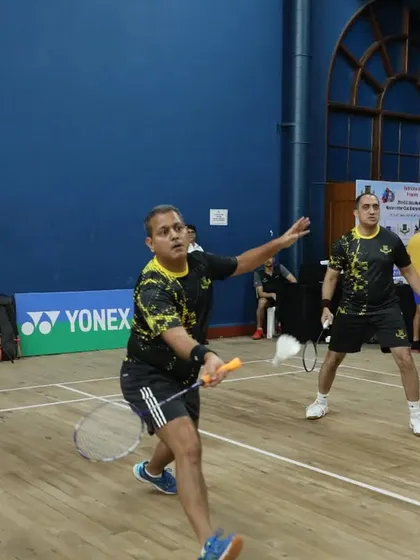 A player lunges for a shot in a doubles match. We ensure high-quality courts and facilities for optimal performance.