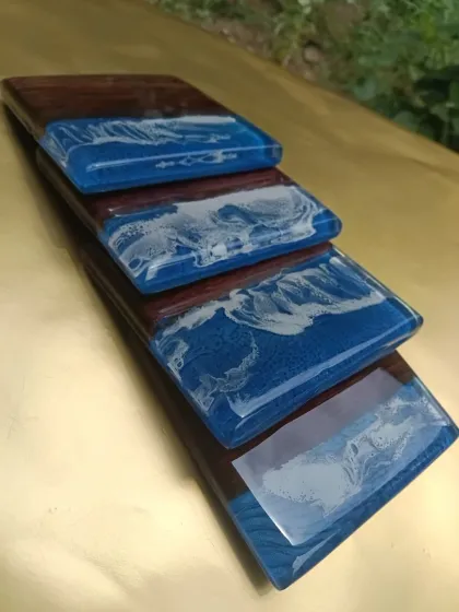 A set of custom coasters with a beautiful ocean wave effect. These are made by combining wood with blue and white resin, bringing a small piece of the sea to your tabletop.
