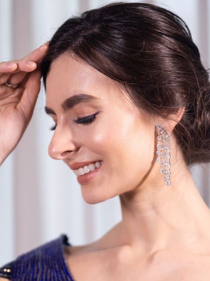 A close-up on the clean, classic makeup. A sharp winged liner and a neat bun create a look of timeless elegance.