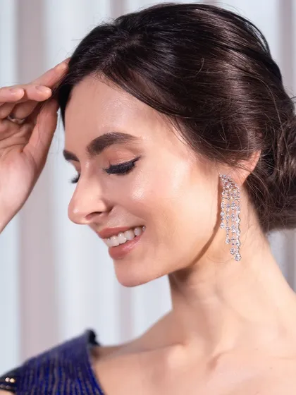 A close-up on the clean, classic makeup. A sharp winged liner and a neat bun create a look of timeless elegance.