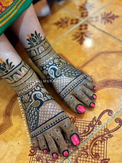 A peacock-themed design for bridal feet, with the birds elegantly placed on the top of the foot and lotus motifs at the ankle.