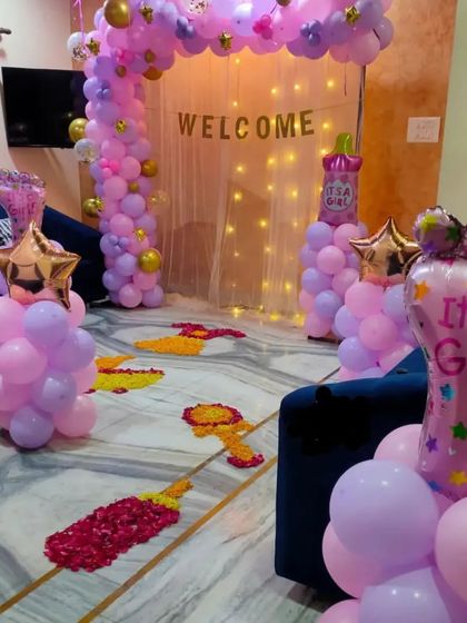 Another view of the welcome party, showing the balloon columns and "It's a Girl" foil balloon.