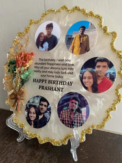 A beautiful birthday photo frame with multiple pictures and a heartfelt message, accented with gold foil and a small floral arrangement.