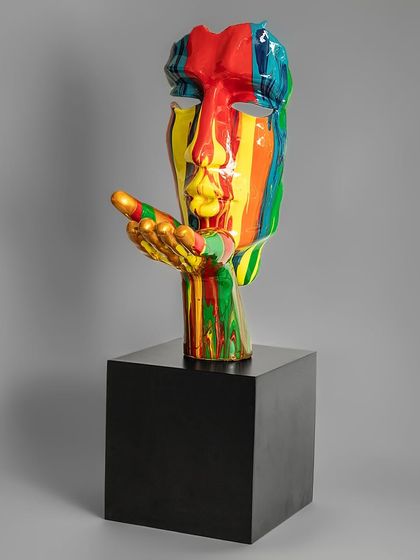 A modern take on classical art, this sculpture features a face with a hand blowing a kiss, all covered in a vibrant, multi-colored paint drip. It's a bold and expressive piece for a contemporary art lover.