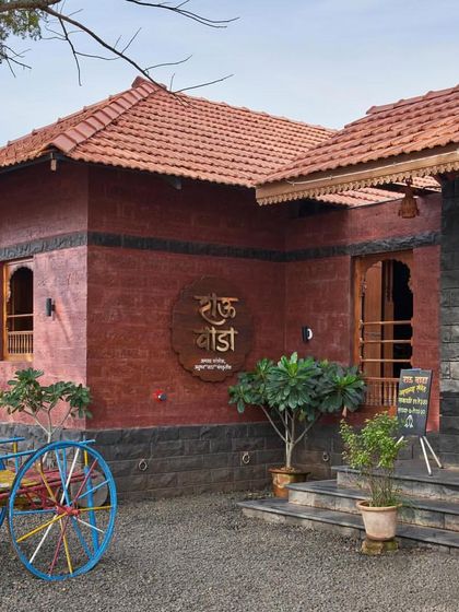 The exterior of the 'Rau Wada', with its tiled roof and a colorful bullock cart, immediately transports visitors to a traditional rural setting.