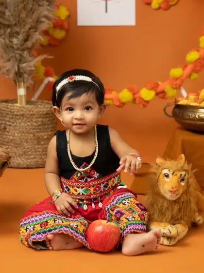 Celebrating the victory of good over evil with a Dussehra themed shoot. This little one looks adorable in her traditional ghagra choli against a vibrant orange backdrop.