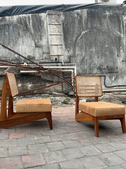 The pair of 'Kangaroo' chairs shown against a rustic, industrial background.