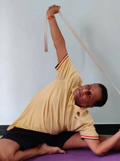 Parivrtta Janu Shirshasana (Revolved Head-to-Knee Pose) using a belt. The belt acts as an extension of the arms, helping you to achieve the bind and deepen the side bend and twist.