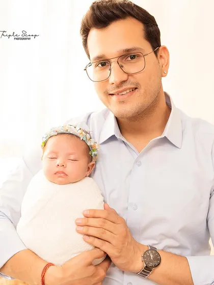 A proud father holds his swaddled newborn. I make sure to capture individual portraits of each parent with the baby to celebrate their unique bond.