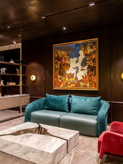 Another view of 'The Outhouse' lounge, showing the interplay of colorful furniture, including a fiery red armchair, against a dark, textured wallpaper. The design is vibrant and full of character.