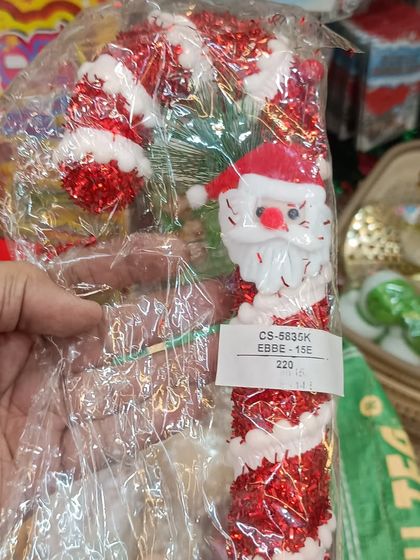 A classic Christmas candy cane ornament featuring a cheerful Santa Claus face. These traditional decorations are a must-have for any Christmas tree.