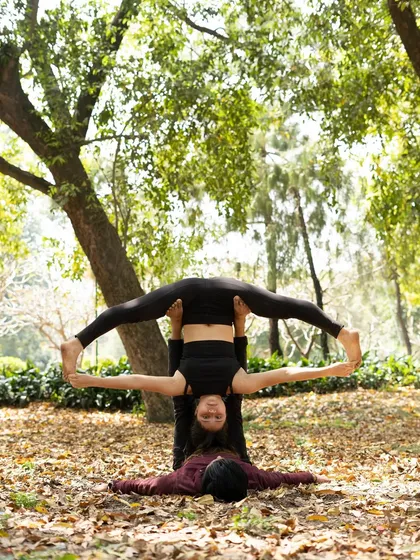 A straddle throne pose from a different perspective, showing the flyer inverted with legs wide.