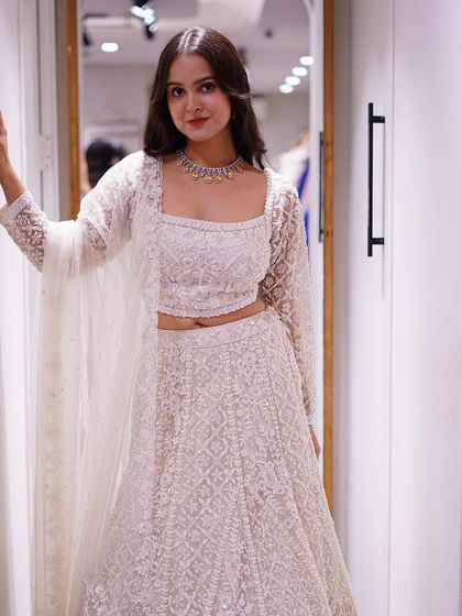 From timeless classics to iconic twists, discover stunning silhouettes like this all-white embellished lehenga.