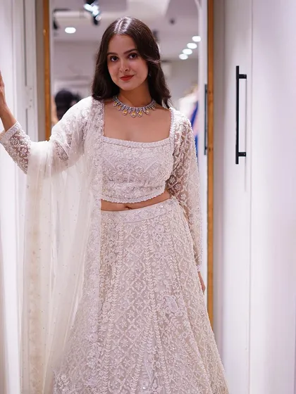 From timeless classics to iconic twists, discover stunning silhouettes like this all-white embellished lehenga.